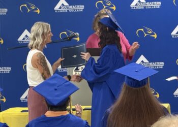 SIC Director of Adult Education Audrey Talbott presents Micah Barnett of Harrisburg with her Illinois High School Diploma during the SIC Adult Education Graduation Ceremony Aug. 11 in the Harry L. Crisp Student Center.